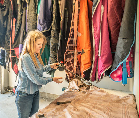 Kristen O'Connor cleaning a horse turnout blanket